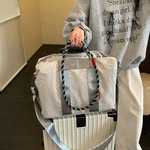 Grand sac de voyage leger de grande capacite avec motif quadrille, sangle et poignees.