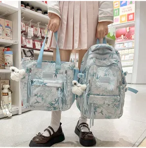 Detailed view of stylish printed canvas backpack and tote bag set with cute plush pendant.