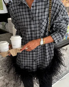 Detailed shot of women's autumn casual plaid long sleeve shirt with trendy black feather hem.
