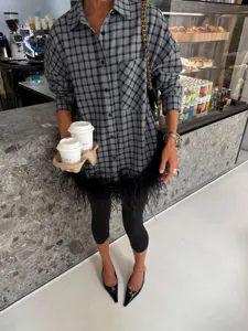 Detailed view of women grey plaid oversized shirt featuring stylish feather fringe hem detail.