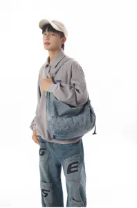 Detail view of stylish casual denim shoulder bag, solid color slouchy design for daily travel.