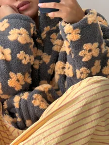 Fleece zip up jacket detail showcasing cozy shearling texture and charming yellow floral print.