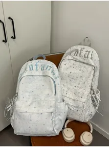Detailed view of casual canvas backpacks featuring star patterns and stylish Gothic lettering.