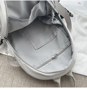 Innendetails des Nylon-Rucksacks mit Staufächern, Reißverschlusstasche und weichem Futter.