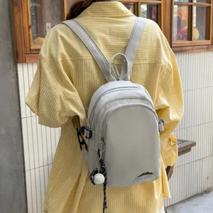 Lässiger minimalistischer Nylon Mini-Rucksack für Damen, leichter Tagesrucksack mit Reißverschlüssen.
