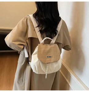 Detail view of casual mini canvas backpack with drawstring closure and stylish contrast flap.