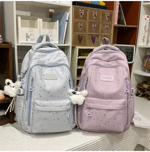 Detaillierte Ansicht des niedlichen Sternen-Schulrucksacks mit flauschigem Bärenanhänger.