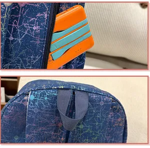 Backpack detail view showing durable navy blue fabric with colorful star print, zipper pocket and handle.
