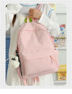 Pink canvas school backpack detail showing cute bear embroidery, front pocket and zipper.