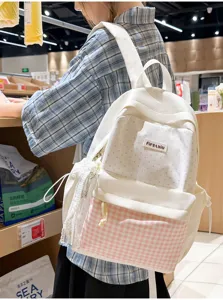 Detail shot of cute pink polka dot and plaid canvas backpack lifestyle view in retail shop.