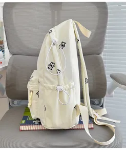 Detailed side view of cute bear print canvas backpack featuring adjustable straps and pockets.
