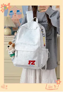 Retro grey canvas backpack detail with cute dog pendant and embroidery letters for daily use.