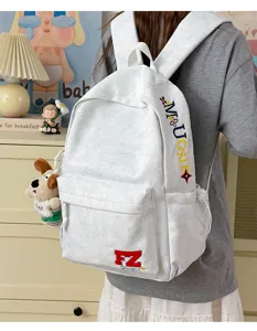 Detailed view of the vintage grey casual backpack with stylish embroidered letters and dog charm.