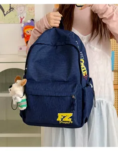 Vintage dark blue canvas backpack with retro letter embroidery and cute dog pendant for use.
