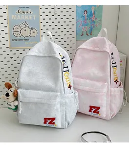Detailed view of casual canvas backpacks in grey and pink, featuring front pockets and cute keychain.