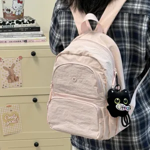 Casual pink nylon backpack with cute cat pendant, lightweight daypack for daily commute.
