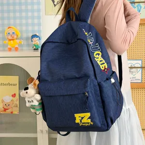 Classic blue denim backpack with embroidered letters and cute dog pendant, stylish and durable.