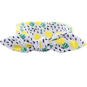 Détail en gros plan du joli bandeau pour bébé avec imprimé ananas jaune et nœud mignon.