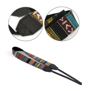 Close-up detail of vintage ethnic woven camera strap fabric and leather connector piece.