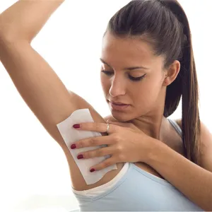Detail view of applying non-woven hair removal paper for smooth underarm depilation.