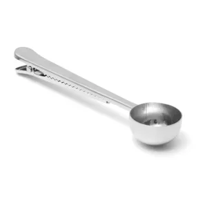 Detail shot of stainless steel coffee scoop with clip, showing polished metal texture.
