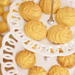 Primer plano detallado de deliciosas galletas de mantequilla doradas dispuestas en un soporte.