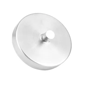 Close-up detail of stainless steel burger press mold with central handle for kitchen use.