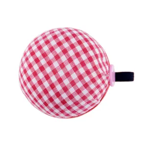 Close-up detail of red and white plaid fabric pin cushion with elastic wristband slot.