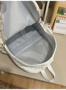 Detailed interior detail view of the cute white backpack showcasing roomy capacity inside.