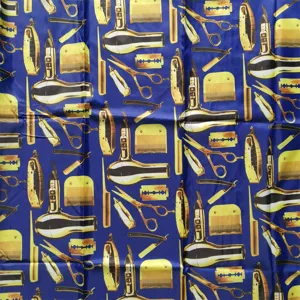 Professional barber cape fabric featuring a stylish blue and gold salon tools pattern print.