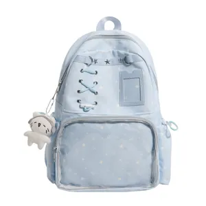 Mochila ita azul claro con patrón de estrellas, ventana transparente y colgante de peluche.