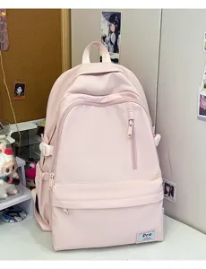 Pink student backpack detail view, featuring front zipper pocket and durable lightweight fabric.