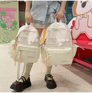 Detailed view of cute Japanese style striped canvas backpacks with front pocket and sweet pendant.
