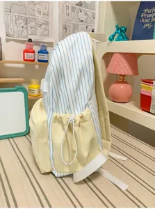 Japanese style striped backpack detail shot showing light blue stripes and yellow pockets clearly.