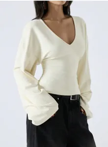 Close-up of the elegant V-neck trumpet sleeve top detail, showing loose dropped shoulder design.