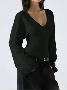 Close-up detail of the black V-neck top featuring long bell sleeves and relaxed fit.