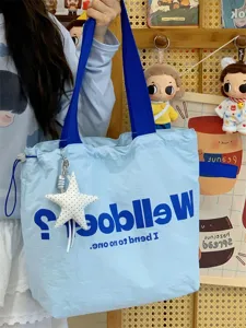 Detail view of the light blue canvas tote bag with contrast blue straps and cute star pendant.