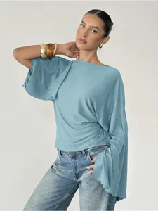 Stylish women's blue boat neck flared long sleeve casual top paired with classic blue jeans.