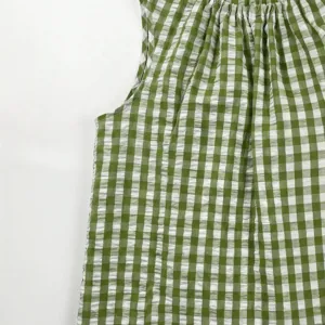 Green white checkered sleeveless top detail, casual crew neck A-hem blouse fabric close up.