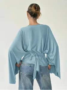 Back view detail of casual light blue batwing sleeve tie-back top showcasing elegant design.