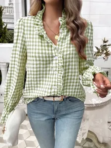 Detail view of the green and white gingham ruffle collar long sleeve blouse in outdoor scene.