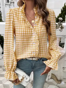 Detail view of yellow plaid blouse featuring ruffle collar and long sleeves for chic style.
