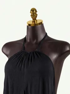 Black pleated halter top detail showing sleeveless backless design and fine texture.