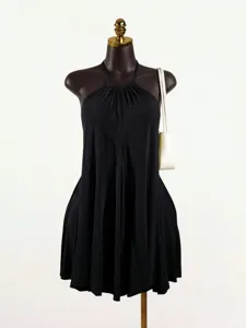 Black pleated halter top detail showcasing sleeveless design and chic resort style wear.