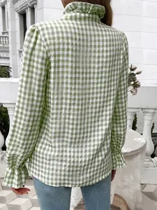 Detailed view of green and white checkered long sleeve blouse with elegant ruffle collar.
