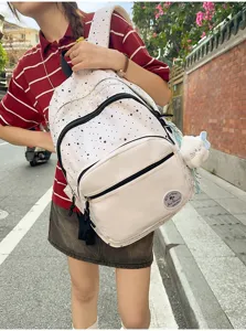 Detailed shot of sweet Japanese style white backpack with black star print, front pocket design.