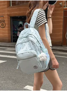Detailed shot of a sweet style light blue star print school backpack with cute plush pendant.