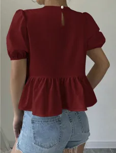 Back view detail of solid red short sleeve puff sleeve peplum top with back pearl button.