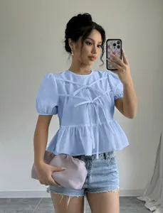 Detail view of a light blue puff sleeve tie front casual blouse worn by a model in a mirror selfie.