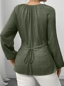 Rückansicht eines armegrünen Langarmbluse mit elegantem Taillenband und unregelmäßigem Saum.